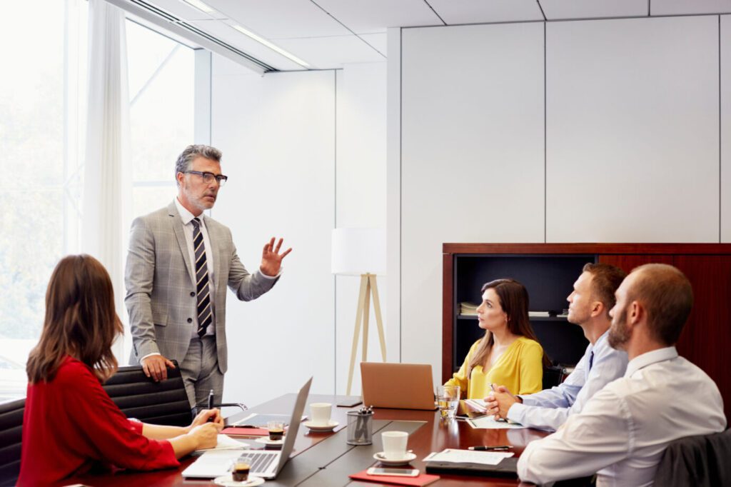 businessman discussing with colleagues at conference table in office meeting