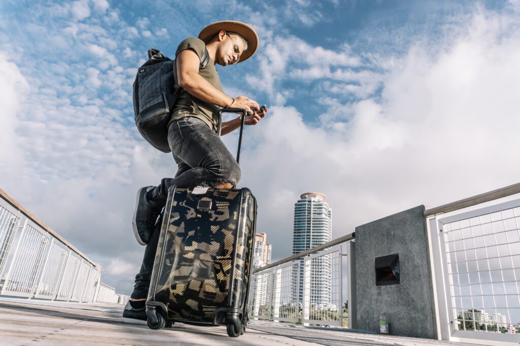 Traveler at airport using phone to grab last-minute holiday deals and Cyber Monday savings before flight.
